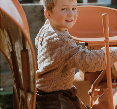 image of little boy in Dear Hayden organic cotton basket weave sweater in taupe