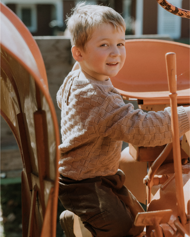 image of little boy in Dear Hayden organic cotton basket weave sweater in taupe