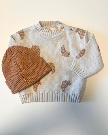 Image shows organic cotton knit croissant sweater with organic cotton knit beanie in acorn. 