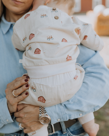 baby wearing organic cotton fleece joggers with farm pattern