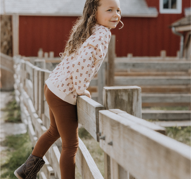 image of little girl wearing organic cotton pink floral rose sweatshirt with magnetic buttons at the back of the neck