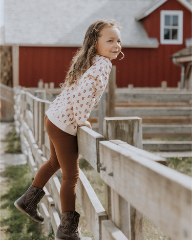 image of little girl wearing organic cotton pink floral rose sweatshirt with magnetic buttons at the back of the neck