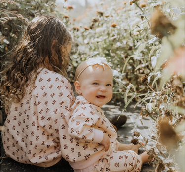 image of baby girl wearing organic cotton pink floral rose sweatshirt with magnetic buttons at the back of the neck