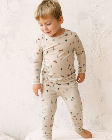 Image shows toddler boy wearing modal pajama set in camping print. 