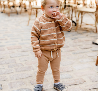 Picture shows little boy standing wearing organic cotton knit cardigan with acorn and cream stripes with Magnetic Buttons.
