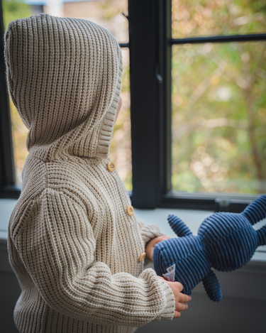 Image shows toddler boy wearing pima cotton knit waffle hoody in oatmeal. 