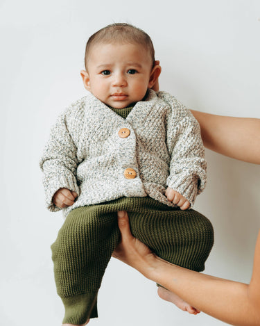 Baby boy wearing marble gray cardigan with Magnetic Buttons and organic cotton yarns. 