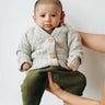 Baby boy wearing marble gray cardigan with Magnetic Buttons and organic cotton yarns. 